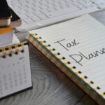 Closeup image of notebook with text TAX PLANNING and calendar on office desk.