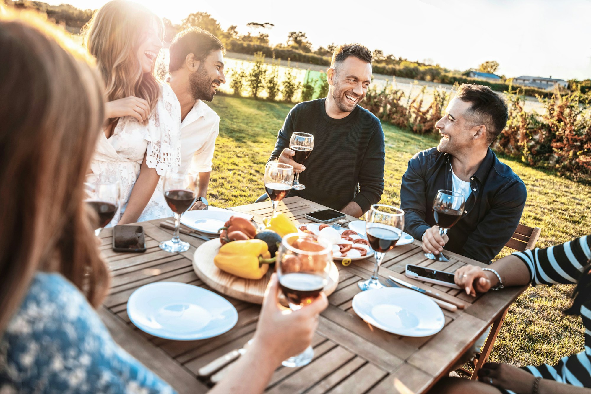 Group of friends having fun at bbq outside dinner in home garden